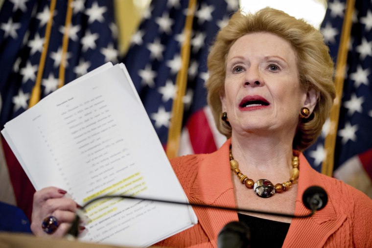 Image: Debbie Stabenow holds up a copy of the proposed Senate Republican health bill