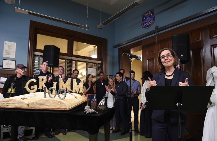 Oregon Governor Kate Brown speaks to the audience as the cast of the TV series Grimm looks on during the celebration of the 100th episode of the series on November 10, 2015 in Portland, Oregon.