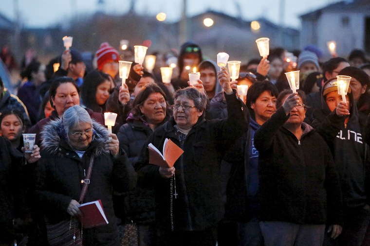 Image: People take part in a march and candlelight vigil in the Attawapiskat First Nation