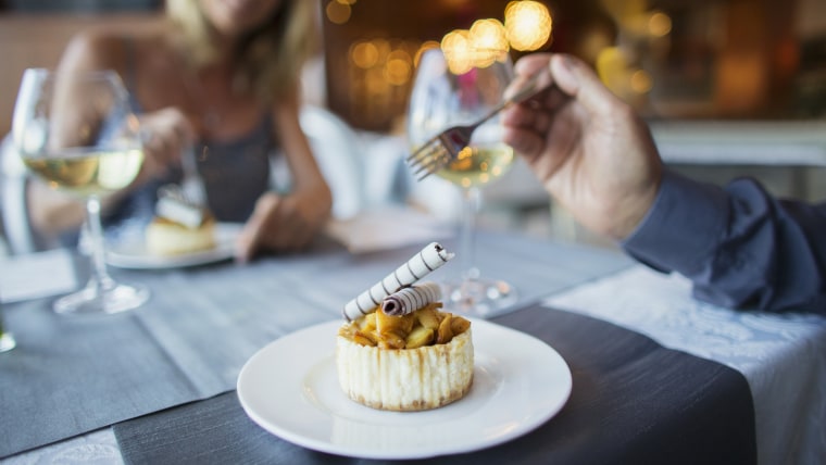 Couple eating dessert in fancy restaurant