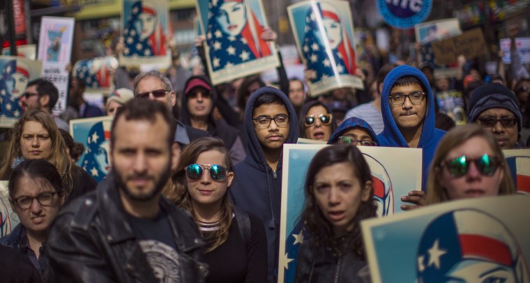 Image: People carry posters during a rally in support of Muslim Americans