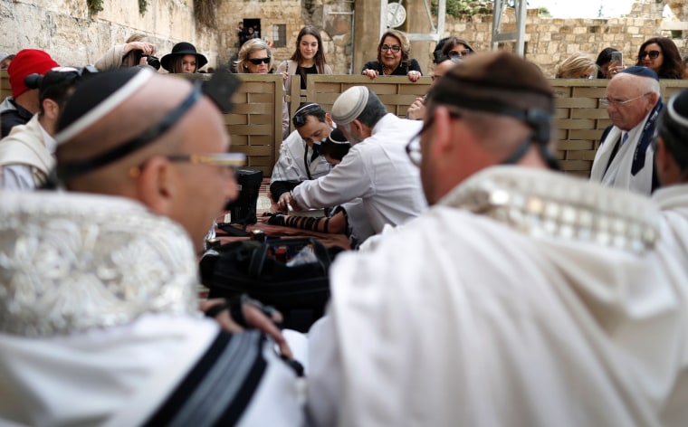Image: Jewish women watch a religious ceremony on the men's side over a separation barrier at the Western Wall.
