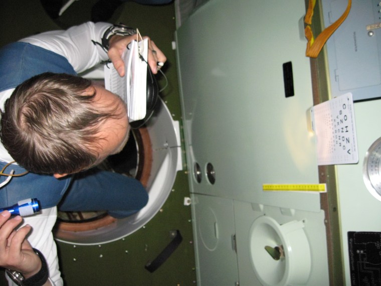 Garriott performing visual acuity tests aboard the ISS