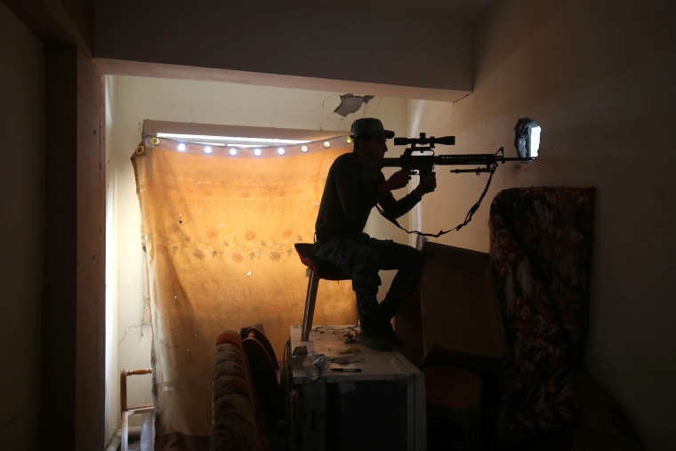 Image: An Iraqi forces member aims his gun towards an Islamic State position on June 24.
