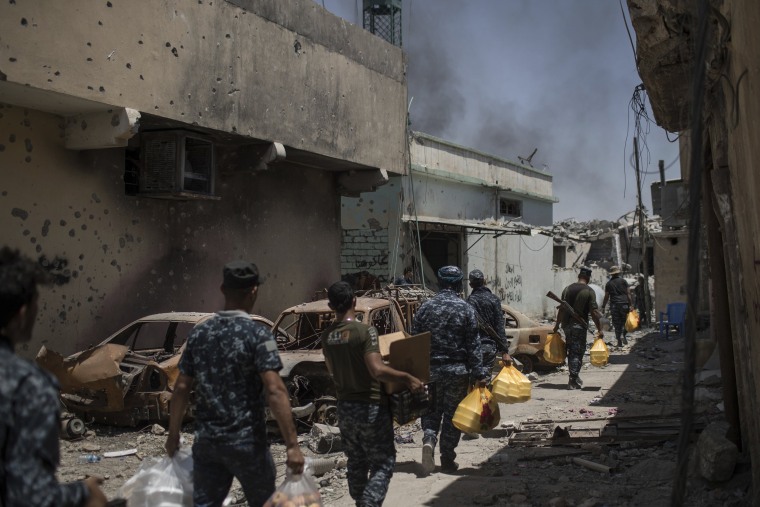 Image: Federal policemen carry food to the front line during fighting against Islamic State militants on June 26.