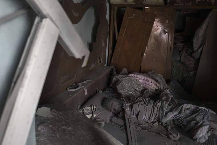 Image: The body of an alleged Islamic State militant lays on a bed in a destroyed house on June 30.