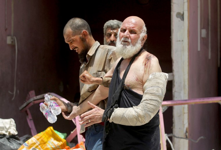 Image: An injured Iraqi wearing a cast and sling over his left arm evacuates from the Old City of Mosul on June 30.