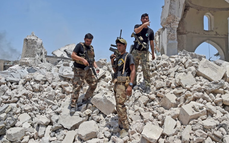 Image: Members of the Iraqi Counter-Terrorism Service stand over the rubble of the destroyed Al-Nuri Mosque on June 30.