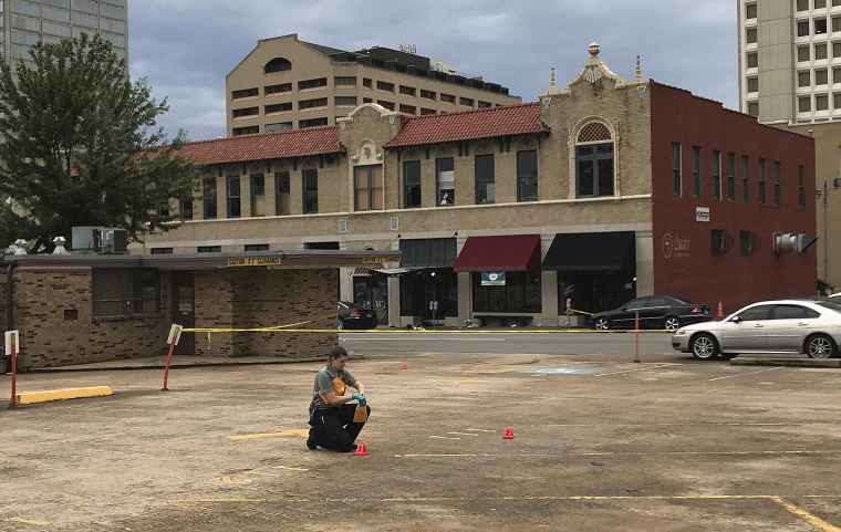 Image: An investigator collects evidence near an Arkansas nightclub