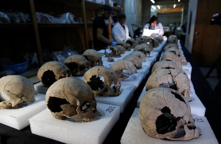 Image: Biological anthropologists from the National Institute of Anthropology and History (INAH) examine skulls discovered at a site near Templo Mayor