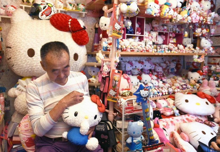 Image: Retired Japanese police officer Masao Gunji posing with his Hello Kitty collection