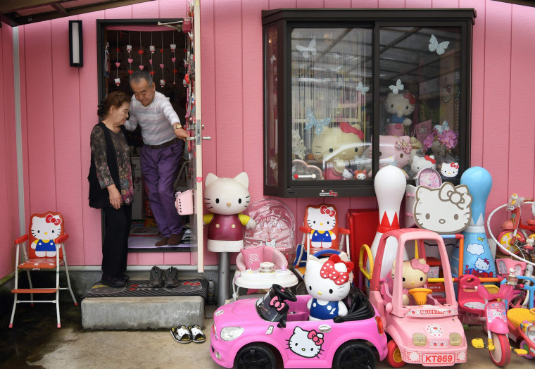 Image: Retired Japanese police officer Masao Gunji posing with his Hello Kitty collection