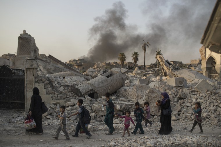 Image: Fleeing civilians walk past Mosul's heavily-damaged al-Nuri mosque during Iraq's war on ISIS