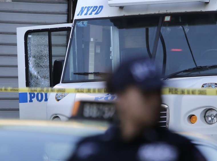 Image: An NYPD vehicle with a cracked window sits on the scene where a police officer was fatally shot