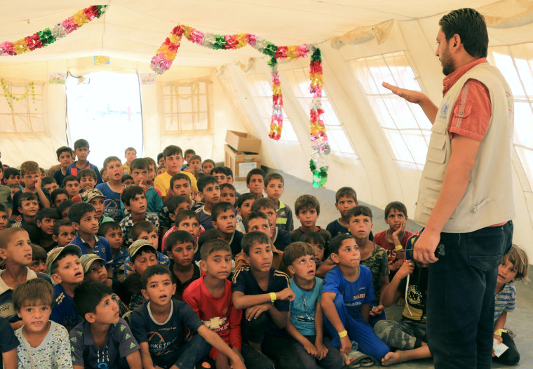 Image: Zaid Adil Sultan teaches a class for displaced Iraqi children in a tent school at tje Hammam al-Alil camp