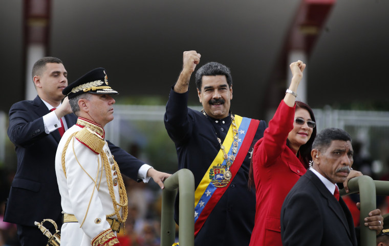 Image: Venezuela's President Nicolas Maduro and first lady Cilia Flores raise their fists during a military parade