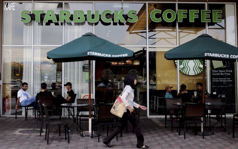 A Muslim woman walks past a Starbucks Coffee shop in Rawang outside Kuala Lumpur, Malaysia, on July 6, 2017. 