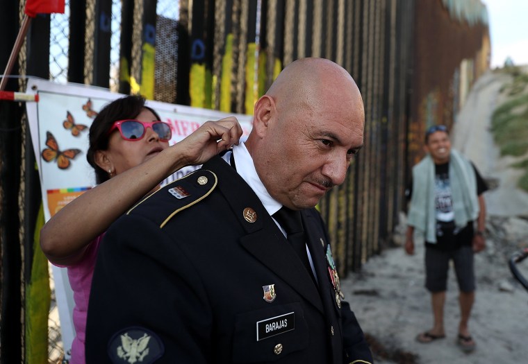 Image: A woman helps a veterans uniform.