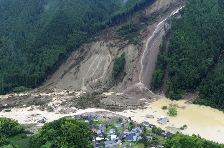 Image: Houses and a road are seen submerged in muddy water after a huge landslide caused by heavy rain