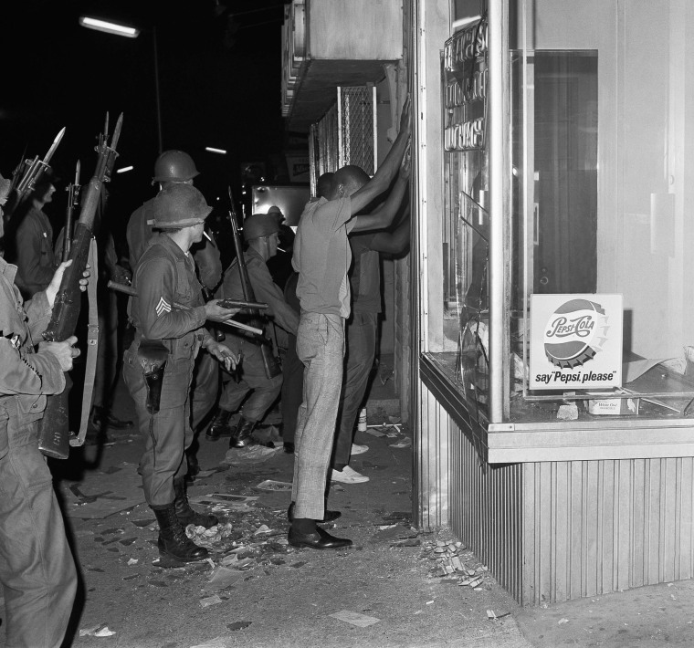 Image: National guardsmen search several people arrested