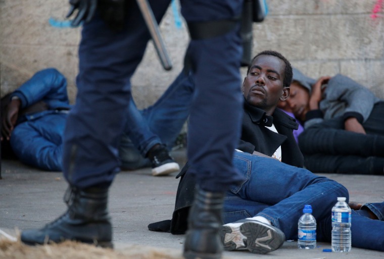 Image: A migrant lays on the ground