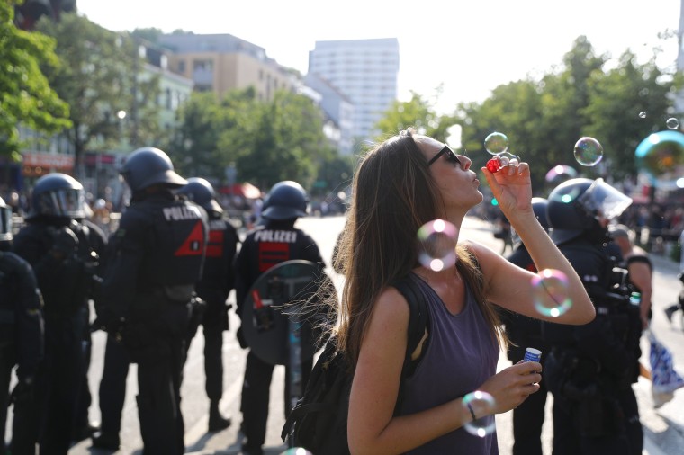 Image: A protester blows bubbles next to German police at a demonstration during the G20 summit in Hamburg