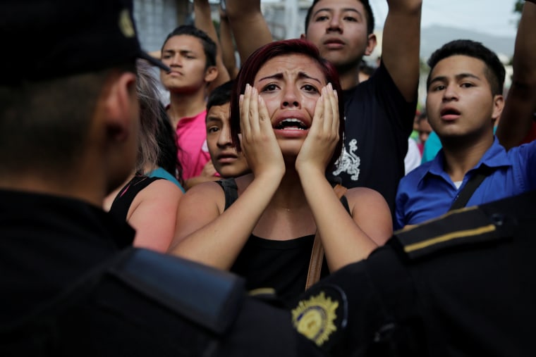 Image: Relative of a juvenile offender reacts as policemen blocks a road during a riot at Las Gaviotas juvenile detention center in Guatemala City
