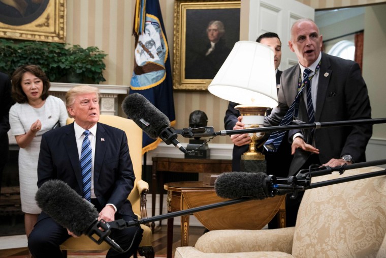 Image: President Donald Trump and White House aide Keith Schiller react as a lamp is bumped by press