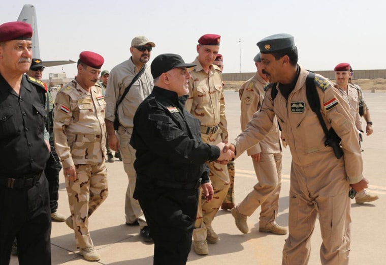 Image: Iraqi Prime Minister Haider al-Abadi, center, shakes hands with army officers upon his arrival in Mosul