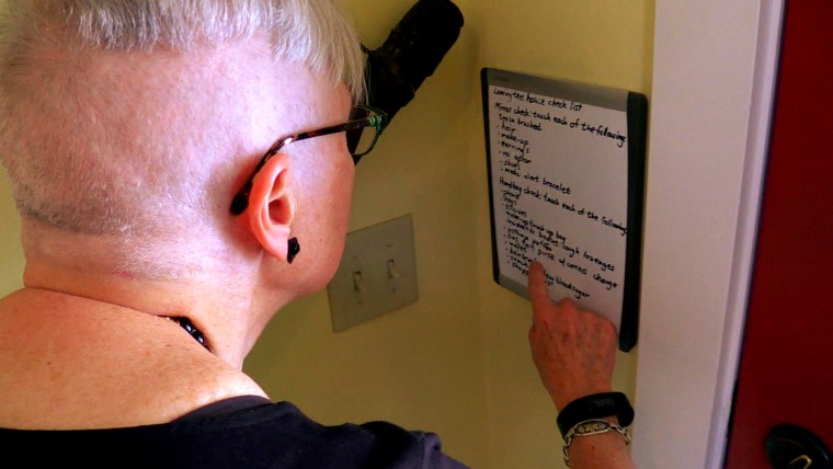 Gerda Saunders looks at a list she posted to help her when she forgets how to do simple tasks.