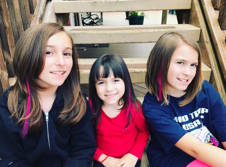 Nicole Sutton's daughters with their pink hair extensions.