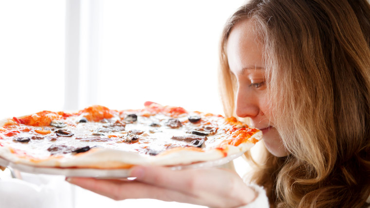 Woman smelling pizza