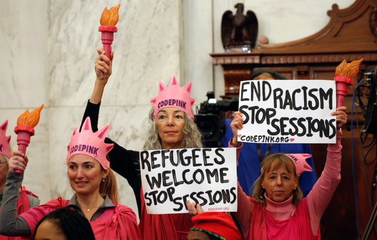 Image: Protesters hold signs at Jeff Sessions confirmation hearing to become U.S. attorney general