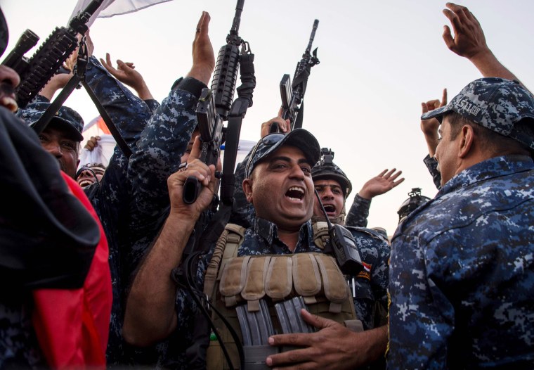 Image: Members of the Iraqi federal police forces celebrate in the Old City of Mosul