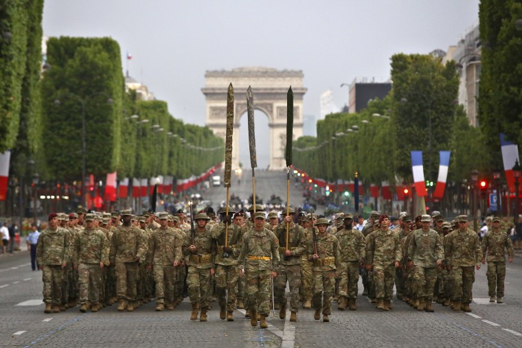 Image: Members of U.S. army 1st Division, U.S. air force, U.S. Navy and U.S. Marines, march down during a rehearsal for the French Bastille Day parade