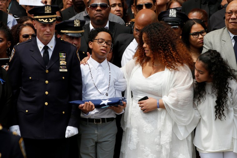 Image: Peter Familia, son of slain New York City Police Department (NYPD) officer Miosotis Familia, holds an American flag outside the World Changers Church following his mother's funeral service in the Bronx borough of New York City
