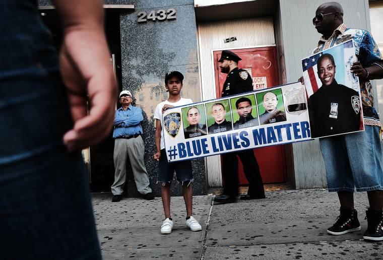 Image: Cameron Hunt stands with his father Calvin holding a Blue lLves Matter banner