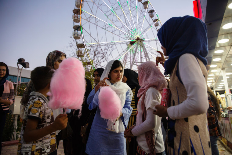 Image: Malala Yousafzai visits an amusement park and eats cotton candy with children displaced by ISIS conflict