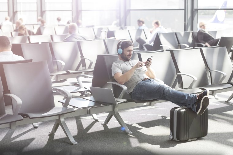 Man with headphones waiting at airport departure lounge