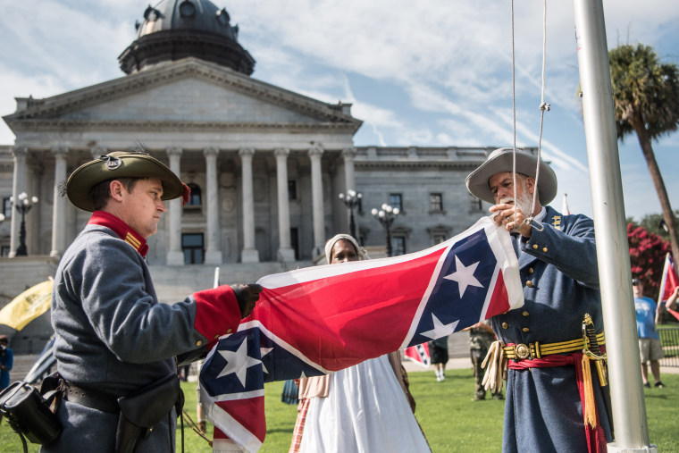 Image: Two men raise a Confederate battle flag on the South Carolina Statehouse grounds