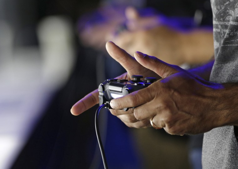 Attendees play video games on the PlayStation 4 at the Sony booth during the Electronic Entertainment Expo in Los Angeles in 2013.