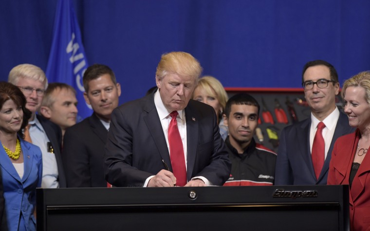 Image: President Donald Trump signs an executive order during a visit to the headquarters of tool manufacturer Snap-on Inc. in Kenosha, Wisconsin, April 18, 2017.