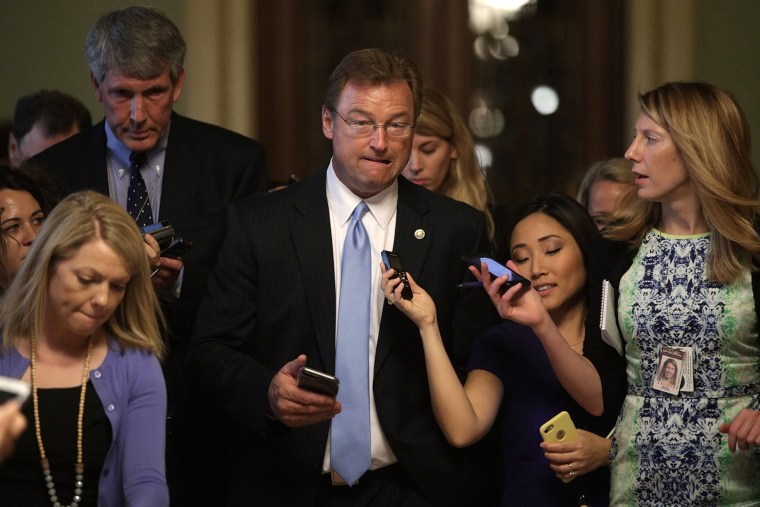 Image: Sen. Dean Heller, R-Nev., center, is surrounded by members of the media