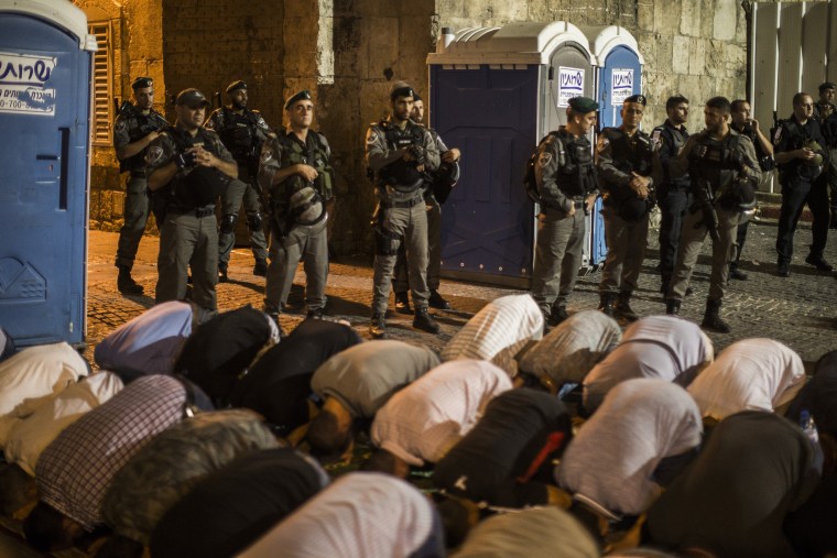 Image: Thousands of Palestinian Muslims pray outside the entrance to the old city of Jerusalem