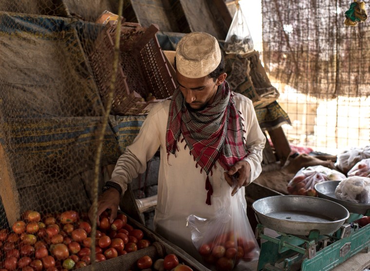 Image: A man sells tomatoes