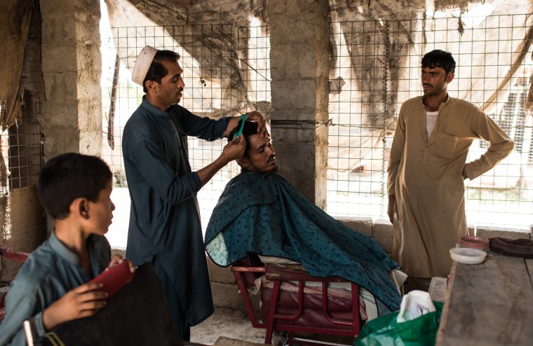 Image: A man has his haircut in a barber shop