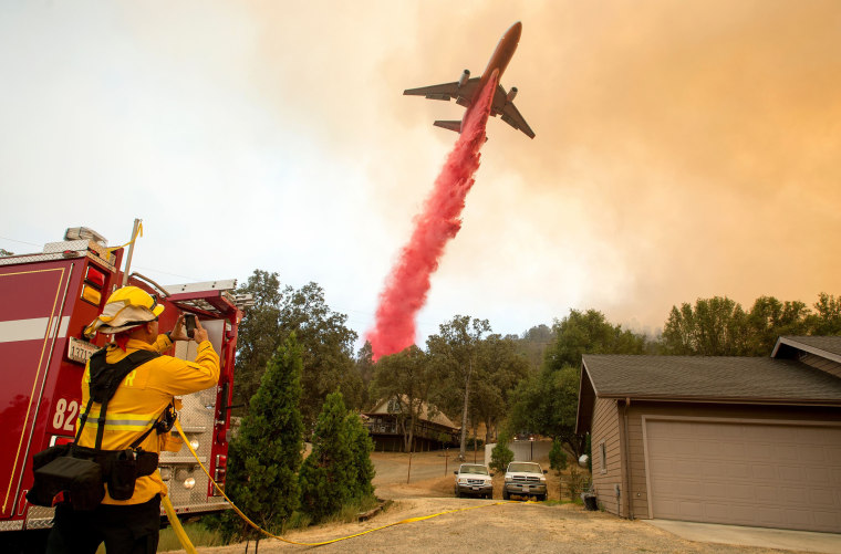 Image: An air tanker drops fire retardant on flames as firefighters continue to battle against the Detwiler fire in Mariposa, California on July 19, 2017.
