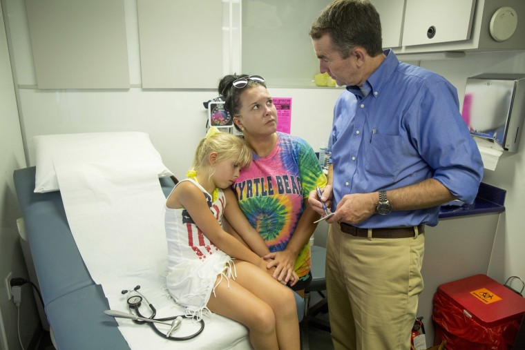 Image: Lt. Governor Ralph Northam gives a diagnosis to Whitney Smith Castle, of Clintwood, Virginia, after he examined her daughter, Katana, 6, during a neurological examination at the Remote Area Medical clinic, July 22, 2017.