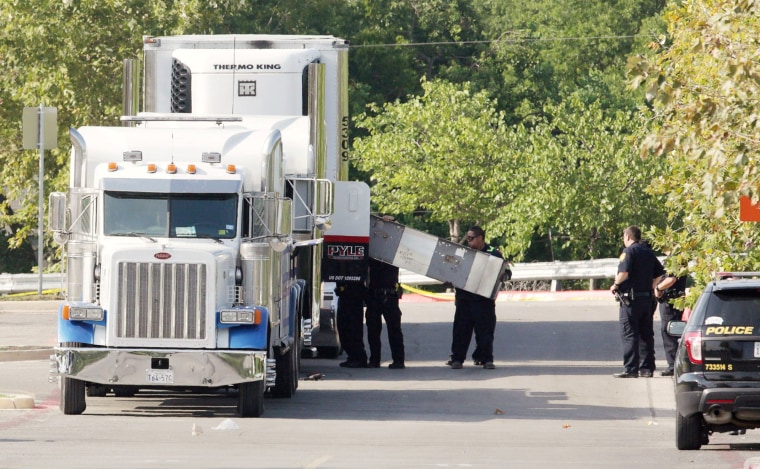 Image: Police work on a crime scene after eight people were found dead inside a sweltering 18-wheeler in San Antonio.