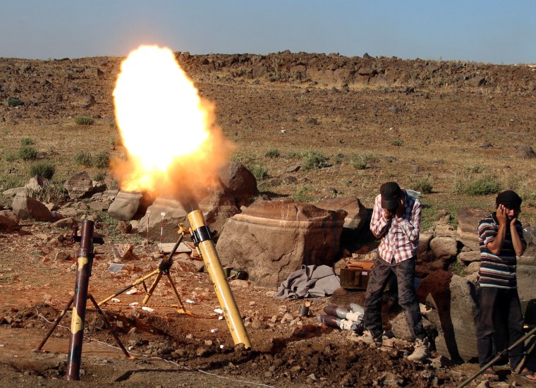 Image: Rebel fighters fire mortar shells towards forces loyal to Syria's President Bashar al-Assad in Quneitra province, bordering the Israeli-occupied Golan Heights